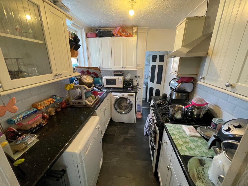 Lot: 79 - MID-TERRACE HOUSE FOR INVESTMENT - Kitchen leading through to bathroom with W.C.
